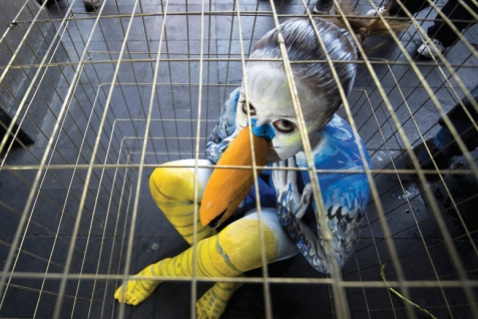sad-young-woman-dressed-as-bird-in-cage